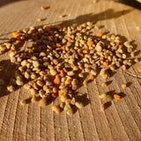 Bioblütenpollen liegen auf Holzscheibe, sie sind Signature Botanicial im Flower Power Gin.