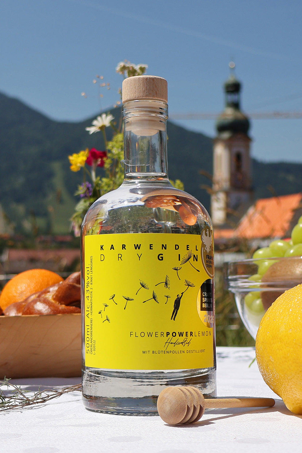 Flower Power Lemon Gin Flasche steht auf Tisch vor Bergpanorama